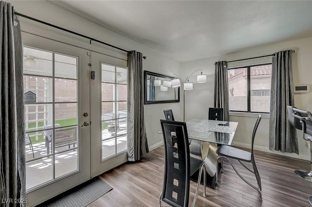 dining area featuring french doors, baseboards, and wood finished floors