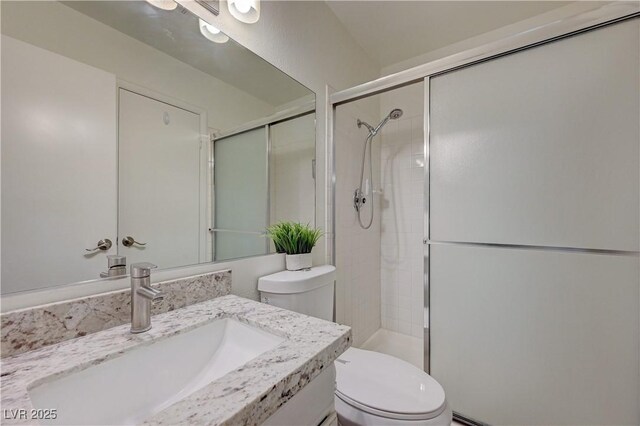 full bathroom with toilet, a stall shower, and vanity