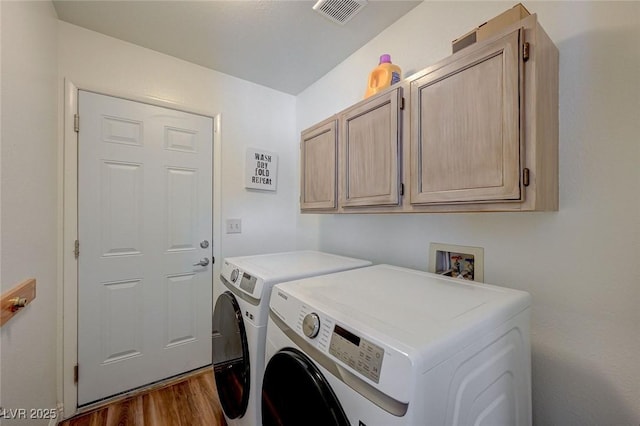 washroom featuring cabinet space, visible vents, separate washer and dryer, and dark wood-style flooring