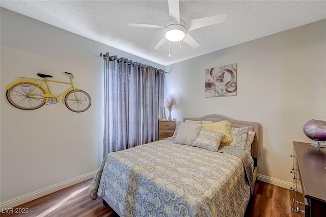 bedroom featuring baseboards, a ceiling fan, wood finished floors, and a textured ceiling