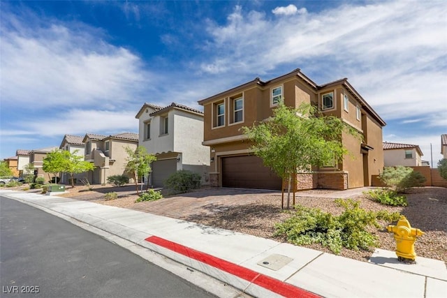 view of front of home featuring a garage, a residential view, driveway, and stucco siding