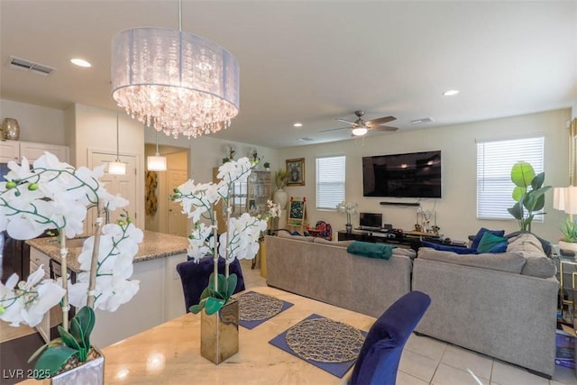 dining space featuring visible vents, plenty of natural light, light tile patterned floors, and ceiling fan with notable chandelier