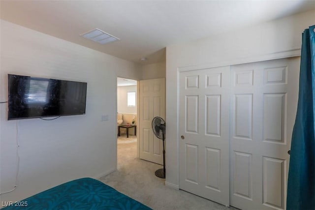 bedroom featuring light carpet and a closet