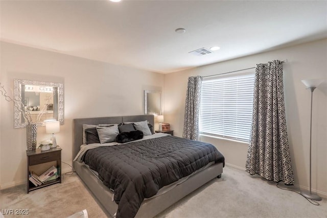 bedroom featuring visible vents, baseboards, and light carpet
