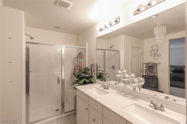 ensuite bathroom with a shower stall, a sink, and visible vents