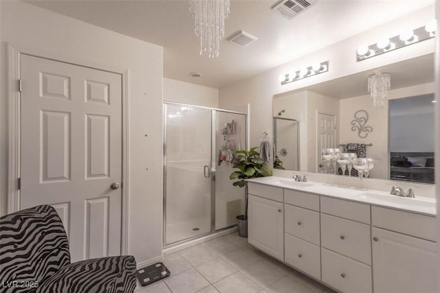 bathroom featuring a chandelier, a sink, tile patterned flooring, and visible vents