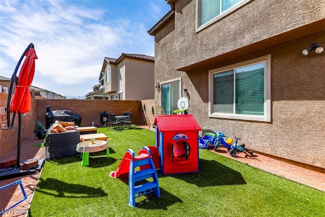 view of play area with outdoor lounge area, a yard, and fence