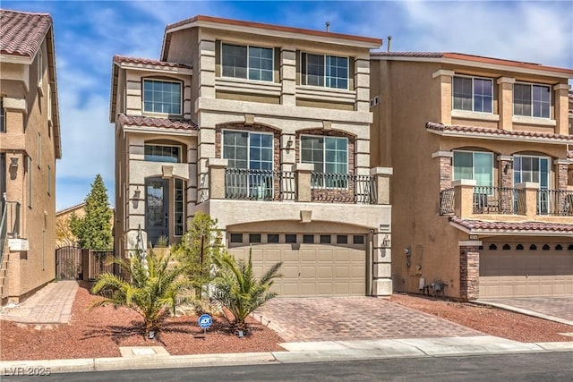 view of front facade with decorative driveway, a garage, and stucco siding
