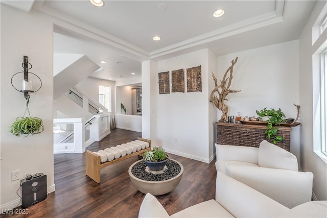 living room featuring a tray ceiling, recessed lighting, wood finished floors, stairs, and baseboards