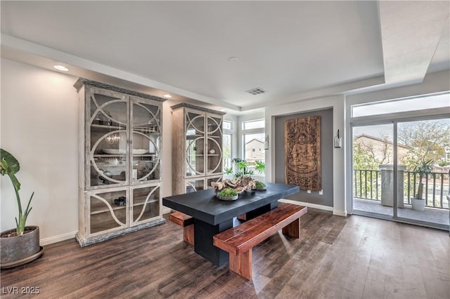 dining room featuring a healthy amount of sunlight, baseboards, dark wood-style floors, and visible vents