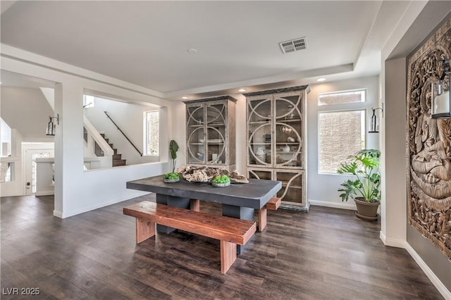 dining space featuring baseboards, dark wood finished floors, visible vents, and stairs