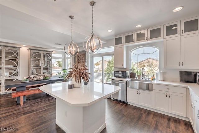 kitchen featuring an inviting chandelier, a sink, light countertops, black microwave, and stainless steel dishwasher
