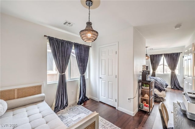 bedroom with visible vents, baseboards, and wood finished floors