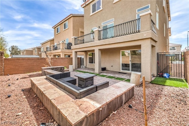 view of patio / terrace with a fire pit, a fenced backyard, and a balcony