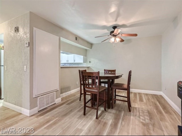 dining space with ceiling fan, wood finished floors, and baseboards