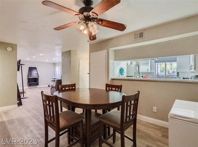 dining space featuring light wood-type flooring, ceiling fan, baseboards, and recessed lighting