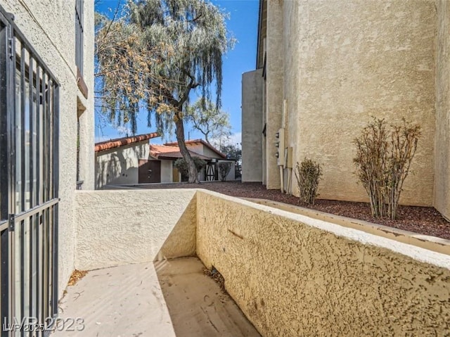 view of side of home featuring stucco siding and a balcony