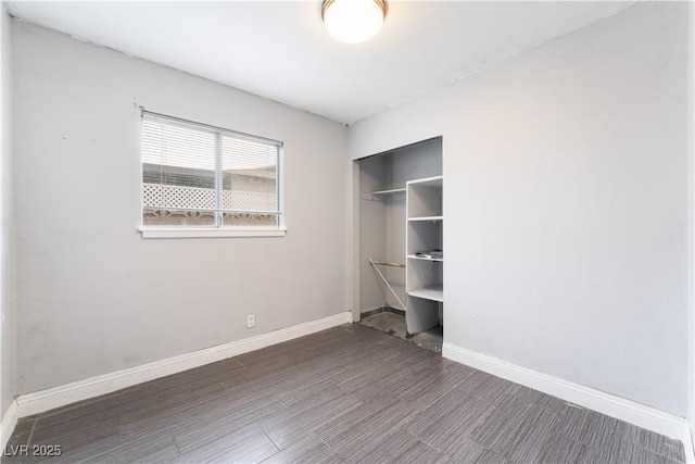 unfurnished bedroom featuring a closet, baseboards, and wood finished floors