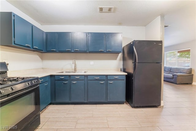 kitchen featuring a sink, visible vents, blue cabinetry, and black appliances
