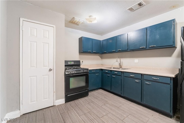 kitchen with visible vents, a sink, light countertops, black gas range, and blue cabinets