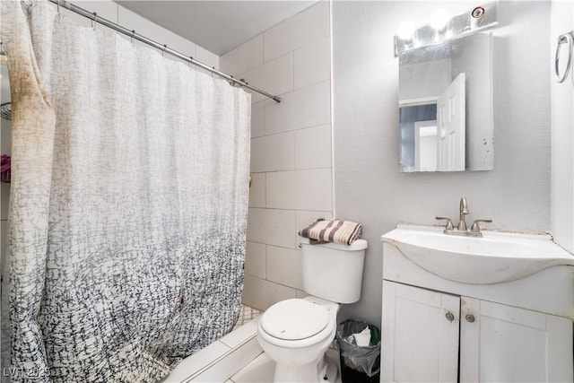full bath with tile walls, toilet, a shower stall, and vanity