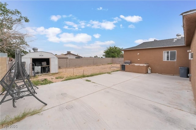 view of patio with a shed, a fenced backyard, an outdoor structure, and area for grilling