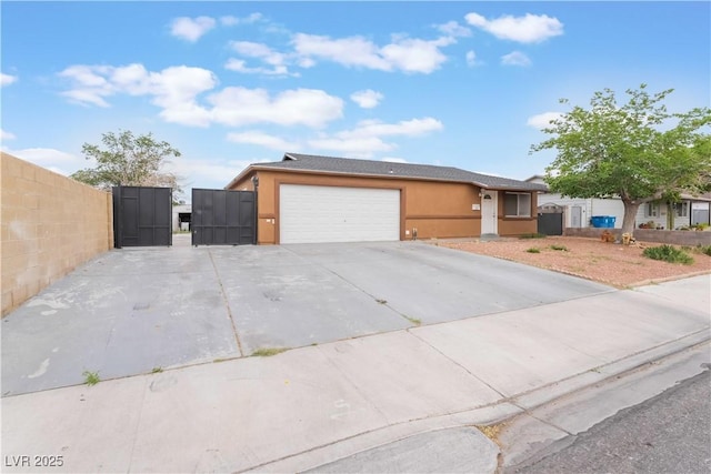 view of front of property featuring stucco siding, fence, a gate, a garage, and concrete driveway