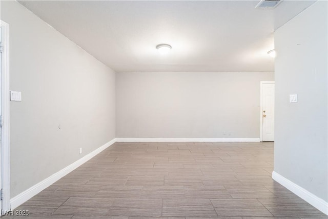 unfurnished room featuring visible vents, baseboards, and wood finished floors
