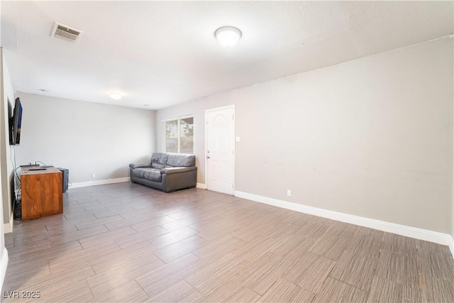 living area with visible vents, baseboards, and light wood-type flooring