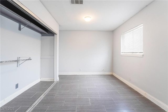 unfurnished bedroom with visible vents, baseboards, and wood finish floors