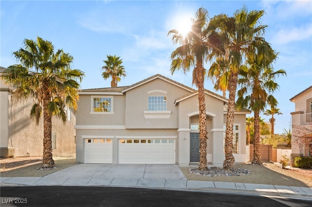 traditional home with a garage, stucco siding, and concrete driveway
