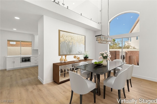 dining space with baseboards, plenty of natural light, and a chandelier