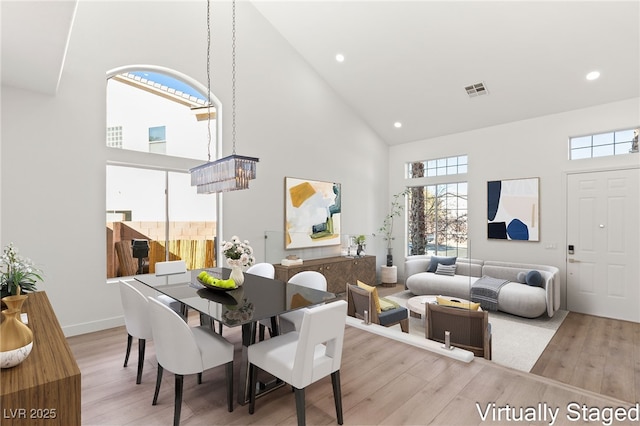 dining space with wood finished floors, high vaulted ceiling, visible vents, and recessed lighting