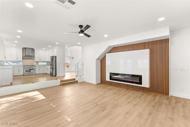 unfurnished living room featuring visible vents, recessed lighting, and light wood-style floors