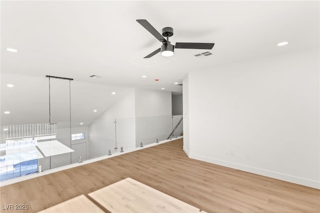 spare room with light wood finished floors, visible vents, and a ceiling fan