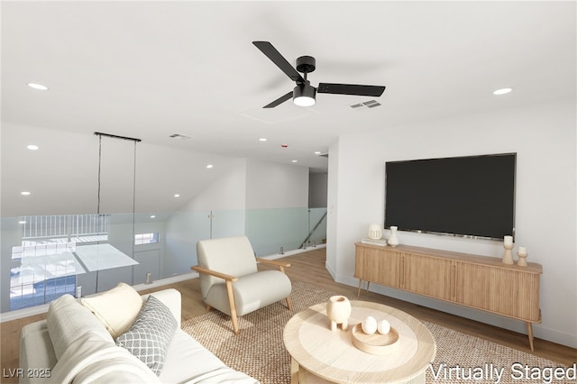 living area with light wood-type flooring, ceiling fan, visible vents, and recessed lighting