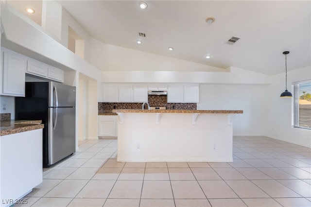 4176 Skywalker Ave, Las Vegas, NV 89120 - kitchen featuring vaulted ceiling, freestanding refrigerator, white cabinets, decorative backsplash, and a kitchen breakfast bar