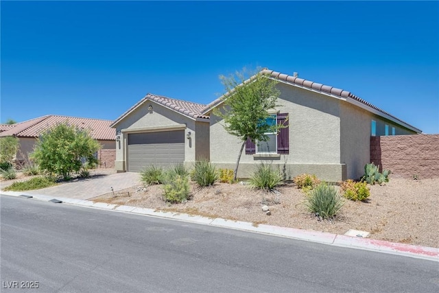2558 Blossom Ave, Pahrump, NV 89048 - ranch-style home featuring concrete driveway, a tile roof, a garage, and stucco siding