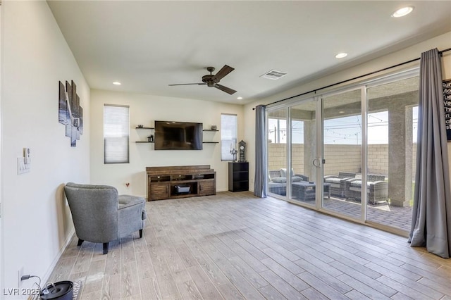 7445 Tinley Creek Ave, Las Vegas, NV 89113 - living area with visible vents, ceiling fan, wood finished floors, and a healthy amount of sunlight