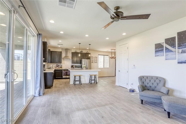7445 Tinley Creek Ave, Las Vegas, NV 89113 - kitchen with wall chimney exhaust hood, visible vents, appliances with stainless steel finishes, light countertops, and open floor plan