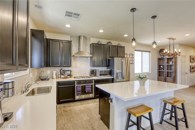 7445 Tinley Creek Ave, Las Vegas, NV 89113 - kitchen with visible vents, a center island, wall chimney exhaust hood, a sink, and appliances with stainless steel finishes