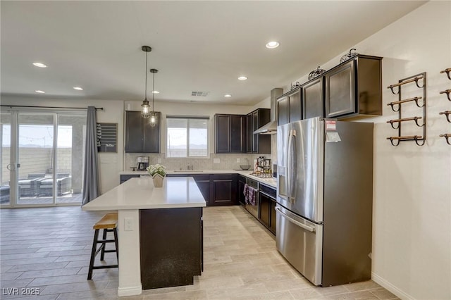 7445 Tinley Creek Ave, Las Vegas, NV 89113 - kitchen with dark brown cabinets, a center island, light countertops, and stainless steel fridge