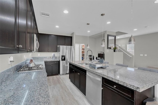 301 Resolute Ave, Henderson, NV 89011 - kitchen featuring stainless steel appliances, a sink, a large island, hanging light fixtures, and dark brown cabinetry