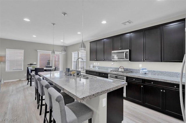 301 Resolute Ave, Henderson, NV 89011 - kitchen featuring a sink, appliances with stainless steel finishes, an island with sink, light wood-style flooring, and recessed lighting