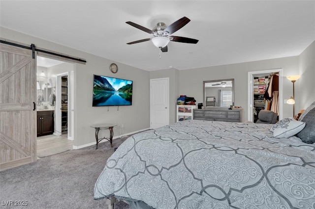 301 Resolute Ave, Henderson, NV 89011 - carpeted bedroom featuring a spacious closet, a barn door, a closet, baseboards, and connected bathroom