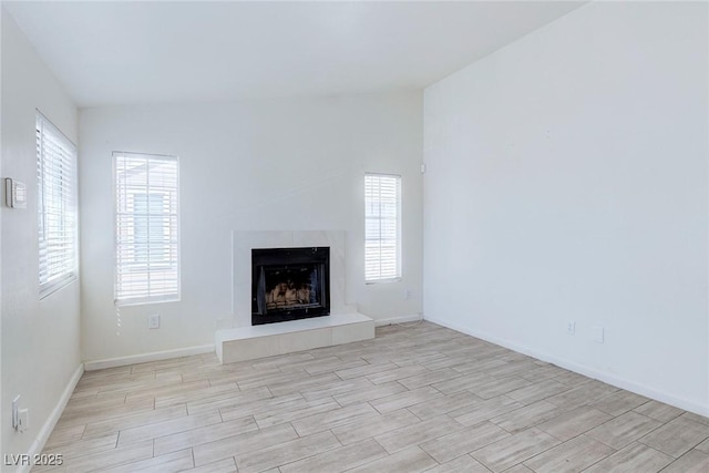 4732 Krissylouise Way, Las Vegas, NV 89121 - unfurnished living room with a fireplace with raised hearth, baseboards, and wood finished floors