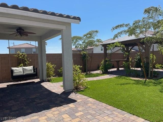 view of patio featuring ceiling fan, a fenced backyard, and a gazebo