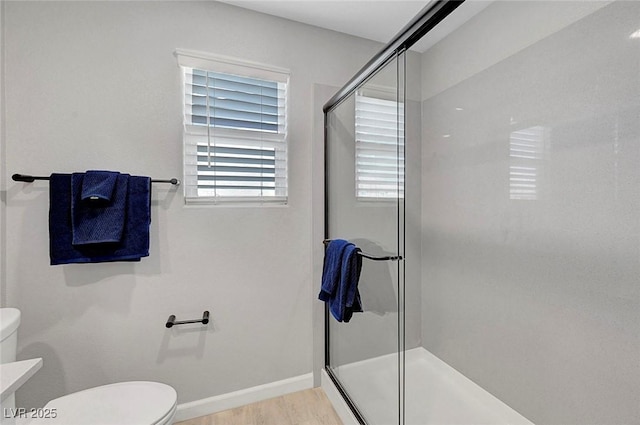 8349 Pollenzo Ave, Las Vegas, NV 89178 - bathroom featuring toilet, a stall shower, wood finished floors, and baseboards