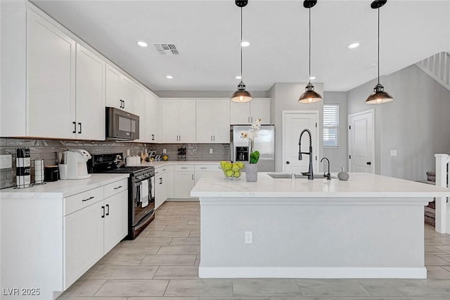 8349 Pollenzo Ave, Las Vegas, NV 89178 - kitchen featuring black appliances, a sink, decorative backsplash, white cabinets, and a center island with sink