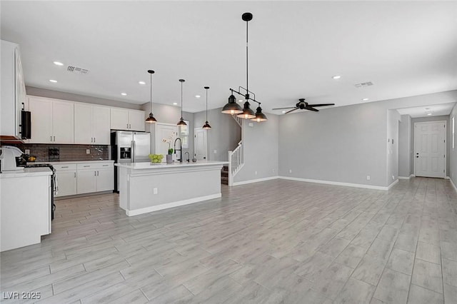 8349 Pollenzo Ave, Las Vegas, NV 89178 - kitchen featuring a ceiling fan, stainless steel fridge, decorative backsplash, open floor plan, and decorative light fixtures